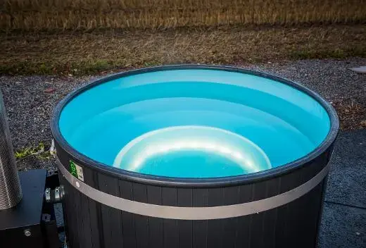 Vasca riscaldata con acqua turchese e luci, situata all'aperto.